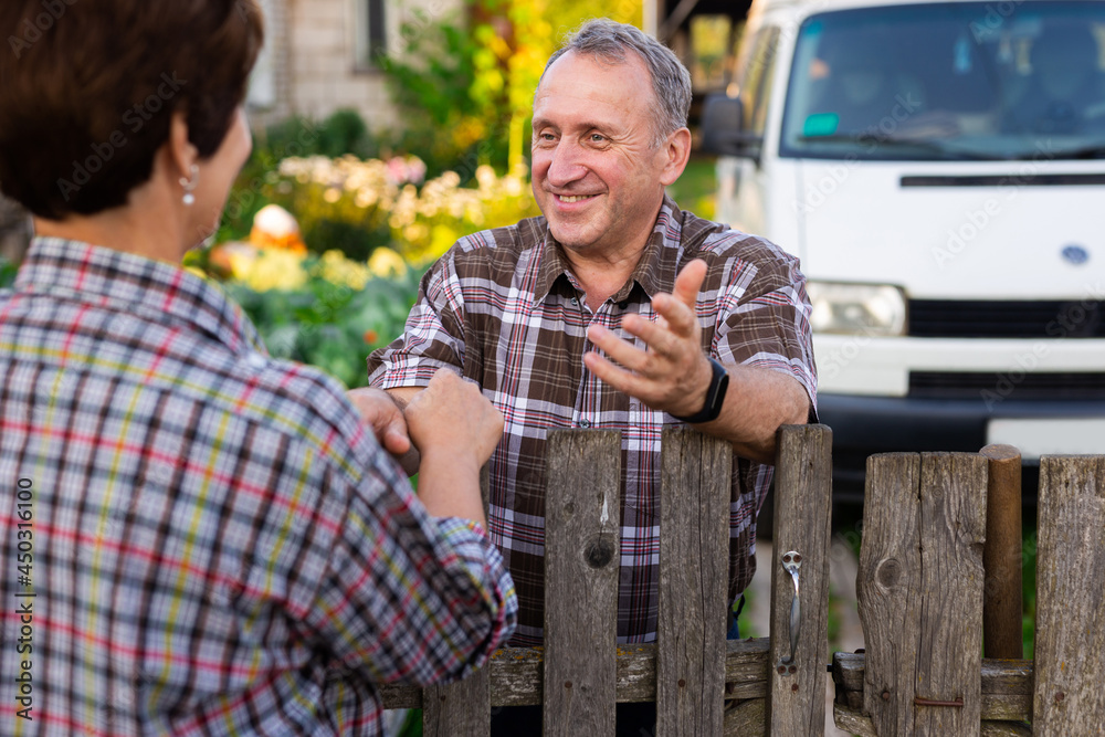 Friendly neighbors wearing flannel shirts shaking hands